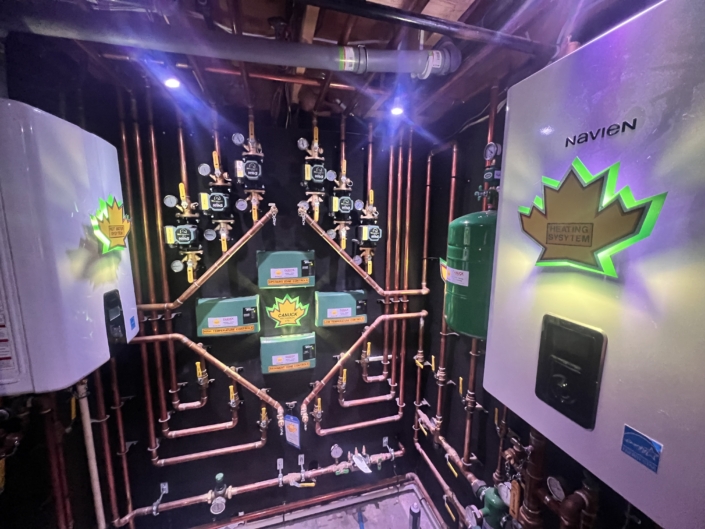 Modern HVAC heating system in British Columbia with gauges, pipes, and controls, featuring lit green and yellow Heating System logos.